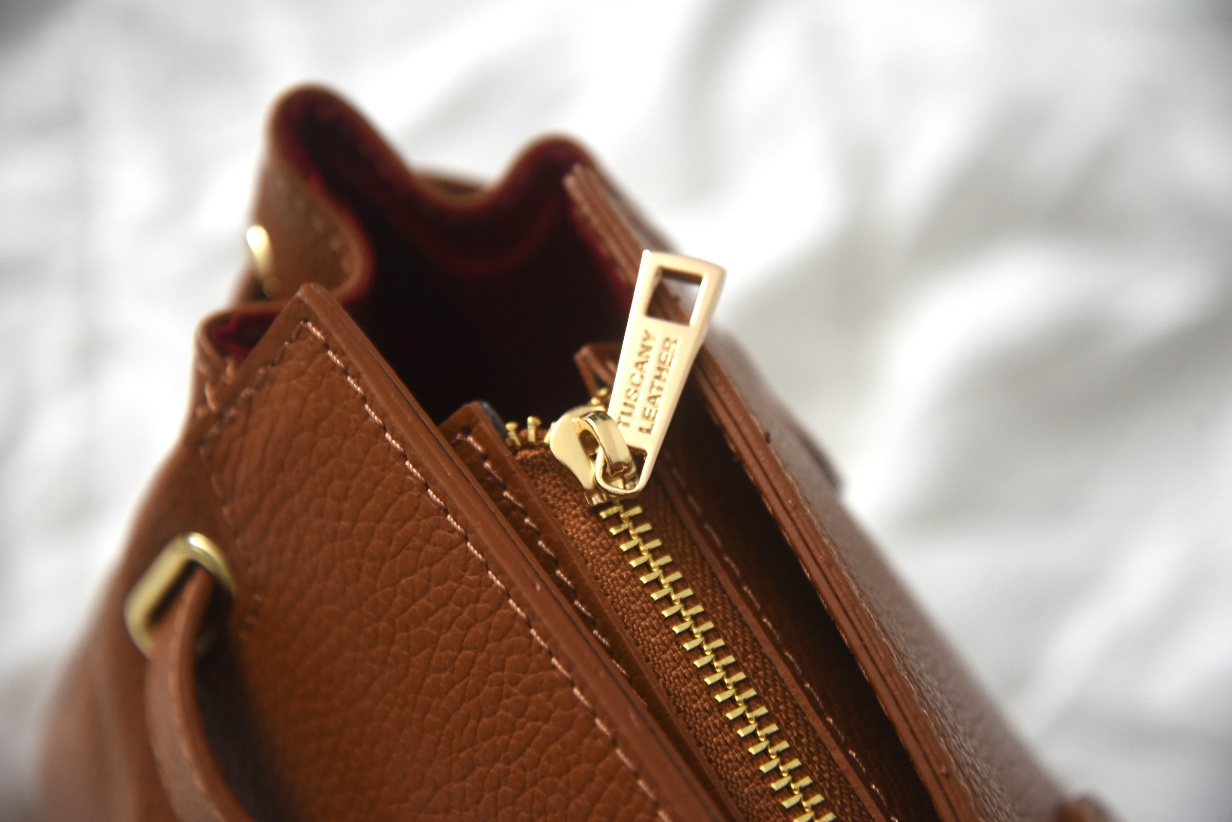 Close-up of a brown leather handbag zipper